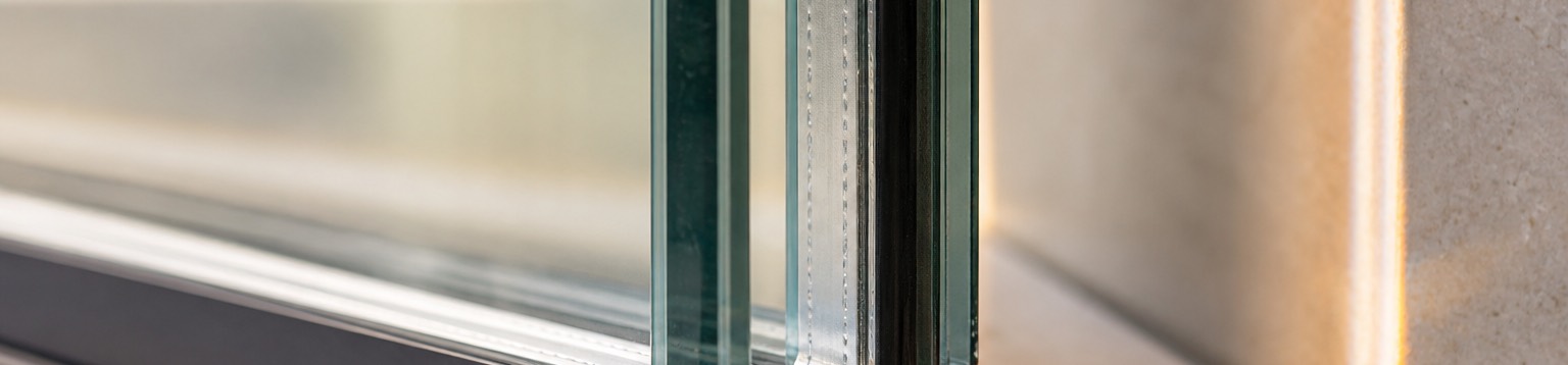 Macro detail of a double-pane insulated glass unit edge and its spacer bar