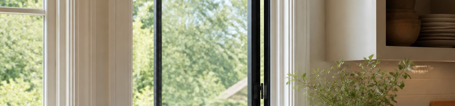A casement window cranked open outward above a kitchen counter